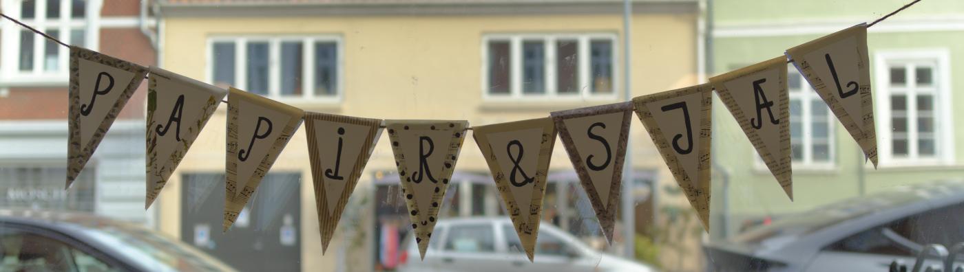 Håndlavet banner af trekantede vimpler pyntet med papir og bogstaver